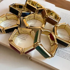 Bracciali elastici retrò in resina con maglie rettangolari e dettagli dorati.