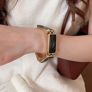 Dettaglio del bracciale elastico in resina retrò con cornice in metallo dorato al polso
