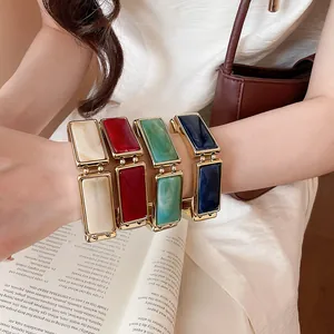 Dettaglio di braccialetti elastici rettangolari in resina colorata al polso