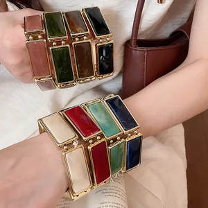 Vista dettagliata di bracciali elastici in resina rettangolare con cornici color oro