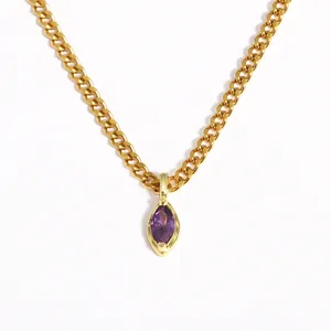 Detailed macro shot of a marquise-cut purple zircon pendant on a gold curb chain.