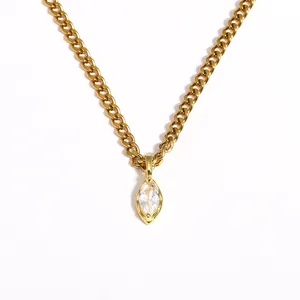 Close-up detail of a gold marquise-cut zircon pendant on a stainless steel chain.