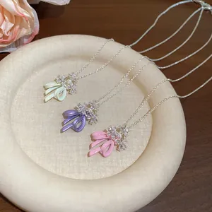 Detailed close-up shot of elegant bow and zircon flower pendants in three sweet pastel colors