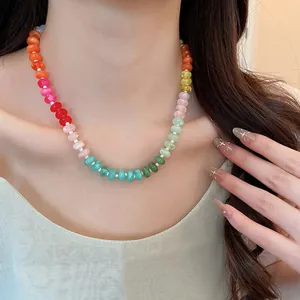 Detail view of a vibrant rainbow acrylic beaded collarbone necklace worn by a model
