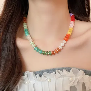 Detailed view of a vibrant rainbow acrylic beaded collarbone necklace on a model