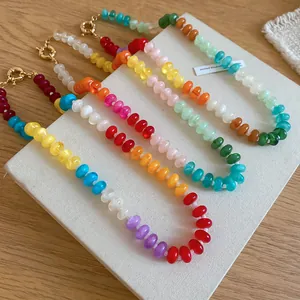 Colorful acrylic beaded necklaces in rainbow patterns with gold clasps on display