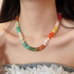 Close-up of a colorful rainbow acrylic beaded necklace worn on an elegant collarbone