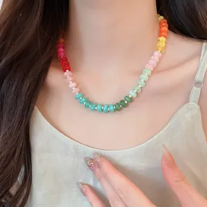 Close-up of a colorful rainbow acrylic beaded necklace on a model's collarbone