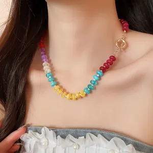 Macro view of a colorful rainbow acrylic beaded necklace worn by a female model