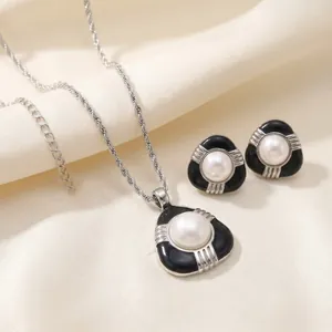 Vue détaillée de la parure de bijoux en émail noir et perles blanches avec collier