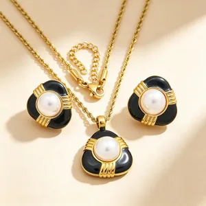 Vue détaillée d'un élégant ensemble de bijoux en émail noir et perles avec chaîne dorée torsadée.