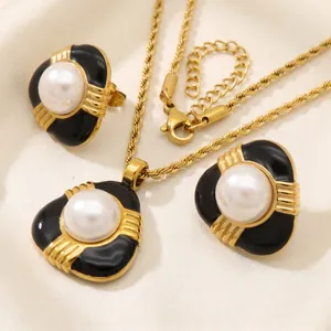 Détail d'un ensemble de bijoux en émail noir et perles avec chaîne torsadée dorée.