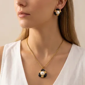 Gros plan d'une parure de bijoux vintage en émail noir et perles de nacre portée par un modèle