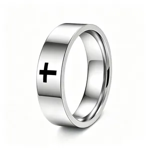 Close-up detail of a polished stainless steel ring featuring an engraved black cross
