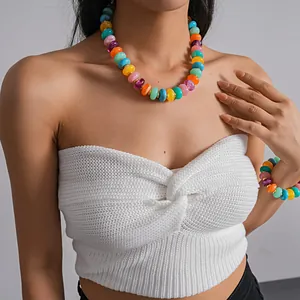 Detailed shot of vibrant multicolored acrylic round bead necklace and bracelet on model