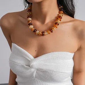 Detailed close-up view of retro acrylic marble bead necklace in amber and brown tones