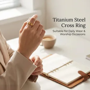 Titanium steel gold cross ring worn on finger in a bright office lifestyle setting