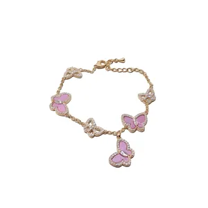 Elegantes Armband mit Zirkonia-Schmetterlingen und rosa Muscheleinlage in Goldoptik
