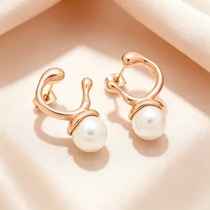 Close-up of irregular rose gold metal earrings with round white pearls on silk