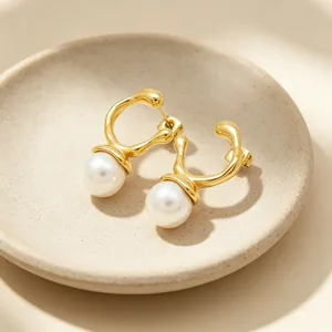 Elegant irregular gold-tone stainless steel stud earrings featuring lustrous white pearls.