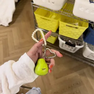 Close-up van een peervormige harsbedel met parelkoord en hartvormige clip