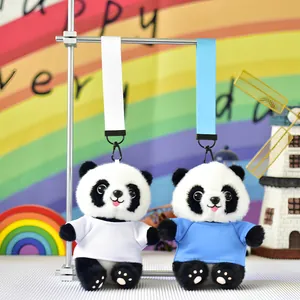 Detailed macro view of two cute panda plush toy keychains in white and blue shirts.