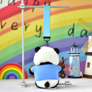 Back view of a cute panda plush keychain wearing a blue shirt, hanging from a strap.