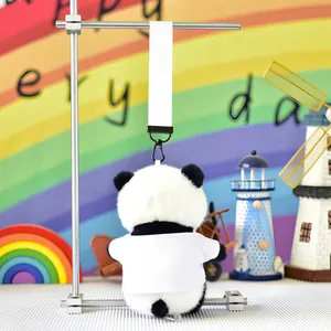 Back view of a cute panda plush keychain wearing a white t-shirt on a rainbow backdrop