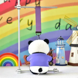 Detailed back view of a cute plush panda keychain wearing a purple t-shirt on a stand