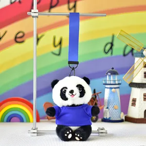 Adorable panda plush keychain wearing a blue t-shirt hanging on a silver display rack