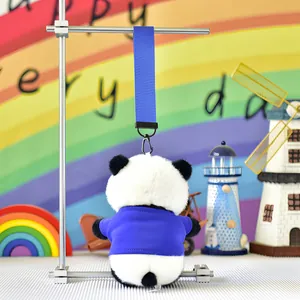 Back view of a cute plush panda keychain wearing a blue shirt on a display stand