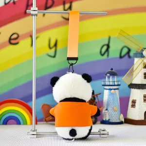 Detailed back view of a cute plush panda keychain wearing a vibrant orange shirt.