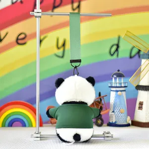 Detailed back view of a cute stuffed panda plush keychain wearing a tiny green shirt