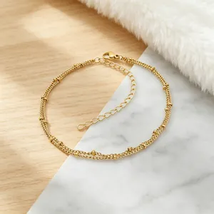 Detailansicht einer goldenen, doppellagigen Edelstahl-Fußkette mit kleinen Perlen-Akzenten