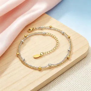 Detailansicht eines zweilagigen Edelstahl-Fußkettchens mit Gold- und Silberperlen.