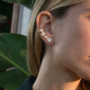 Gold plated stainless steel ear cuff with clear square zircon stones on female model