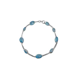 Elegante zilverkleurige armband met acht lichtblauwe ovale gefacetteerde edelstenen op wit