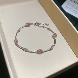 Detailopname van een zilverkleurige armband met champagne ovale stenen in een doosje