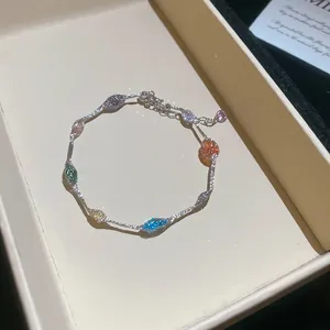 Detail van kleurrijke bedeltjes in de vorm van snoep op een zilverkleurige armband