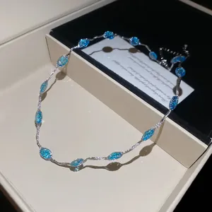 Detailweergave van een zilveren ketting met blauwe edelstenen in een luxe geschenkdoos