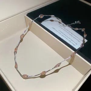 Detailweergave van niche-design ketting met champagne ovale stenen in een geschenkdoos