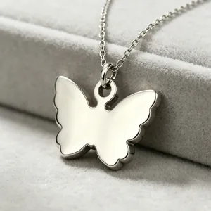 Detailed macro view of a silver-toned butterfly pendant with a smooth polished mirror finish