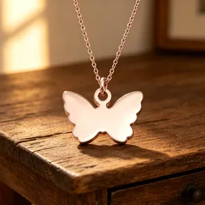 Close-up detail of a rose gold butterfly pendant necklace with a smooth mirror finish