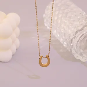 Dettaglio di un elegante collana con ciondolo a ferro di cavallo in oro inossidabile