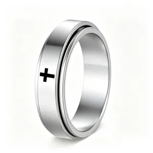 Close-up of a silver stainless steel spinner ring with a black cross design