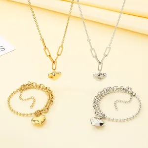 Detail von Herzanhänger-Halsketten und doppellagigen Armbändern in Gold und Silber.