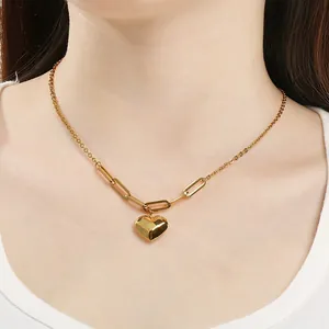 Detailansicht eines polierten goldenen Herzanhängers an einer Edelstahlkette