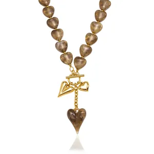 Elegant heart-shaped acrylic bead necklace with gold-toned charms and OT buckle.
