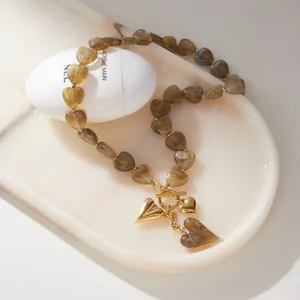 Close-up of heart-shaped acrylic bead necklace with gold OT clasp and heart pendants