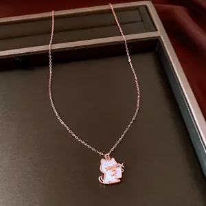 Close-up detail of rose gold necklace with shell inlay cat pendant on jewelry tray